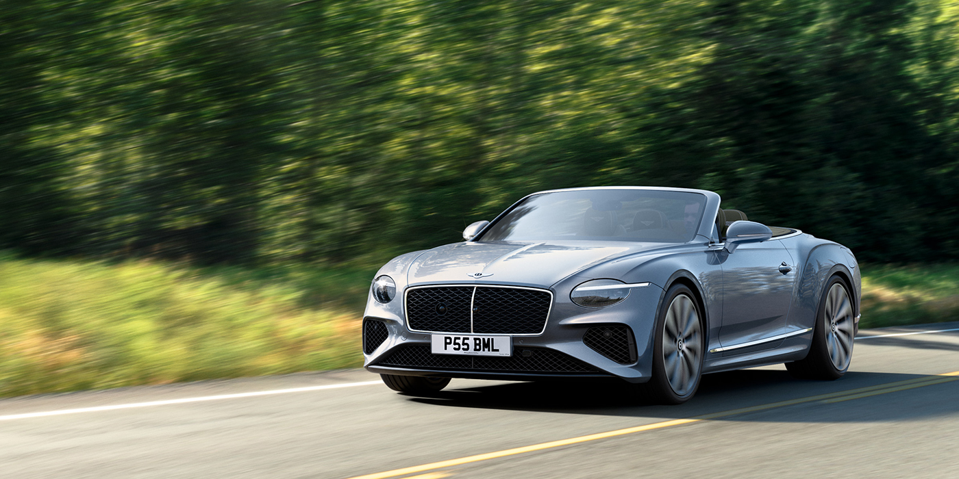 Bentley Taipei New Bentley Continental GTC convertible front view in Silverlake paint with 22 inch ten spoke wheels, driving dynamically on a country road