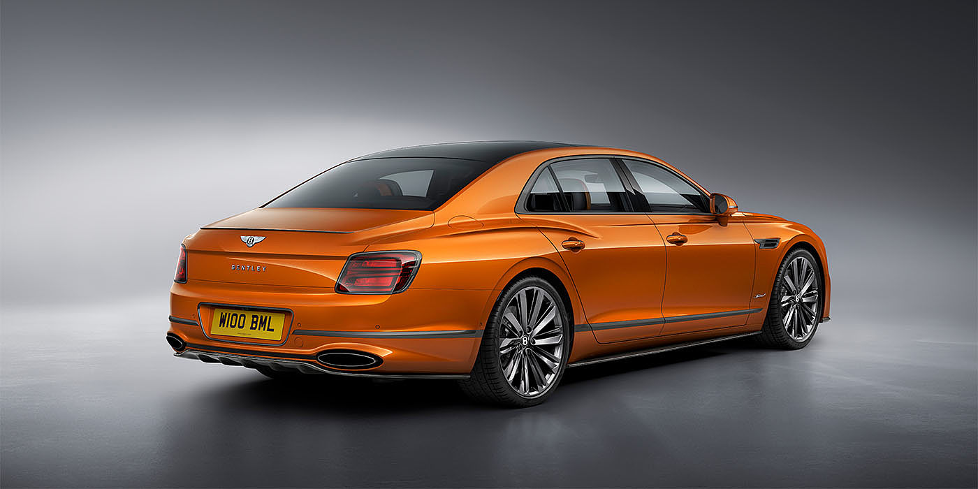 Bentley Taipei Bentley Flying Spur Speed in Orange Flame colour rear view, featuring Bentley insignia and enhanced exhaust muffler.
